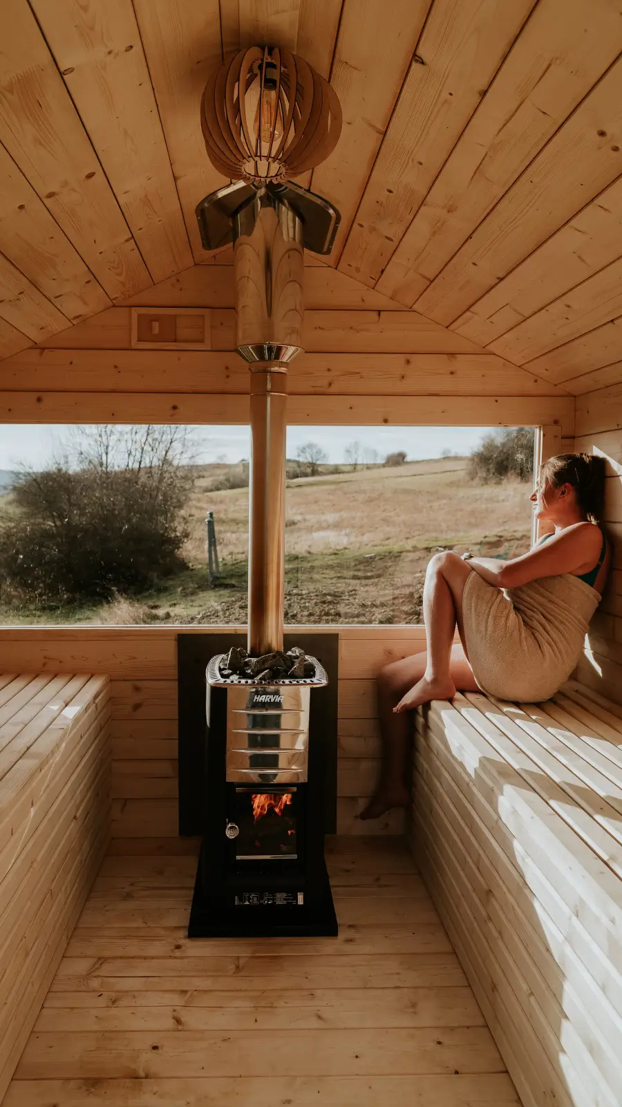 Kobieta podziwiająca piękne widoki widoczne z sauny ogrodowej Stodoła